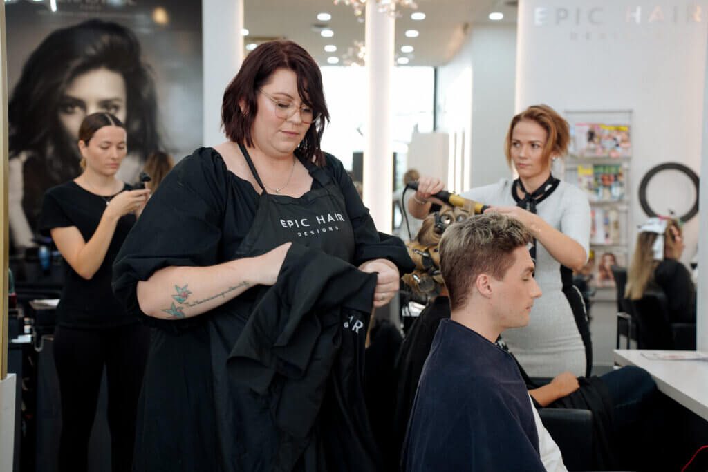 Epic stylist consulting with a male client during a haircut appointment