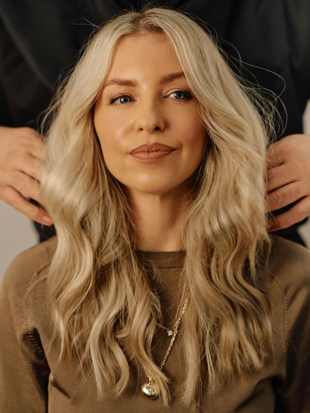 Blonde client with long soft waves after an Epic Hair Designs salon service