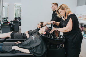 hairdressers washing hair at basin who have discovered Hairdresser Pathways to Australia