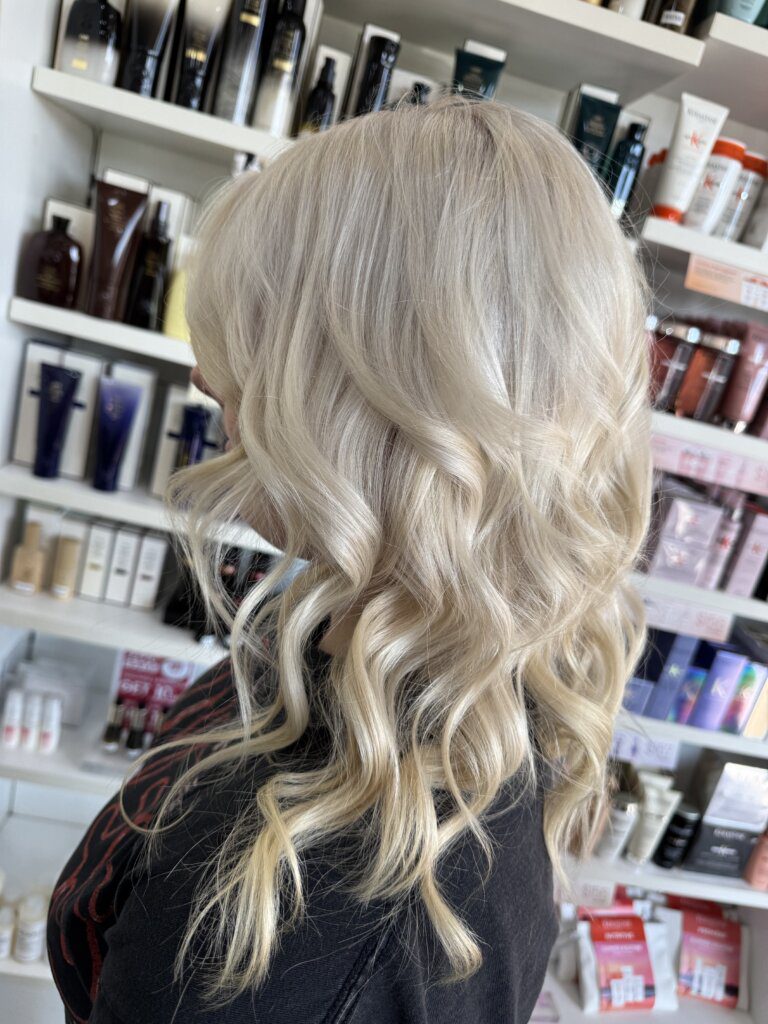 Bright Slavic Doll Blonde hair with a polished porcelain-blonde finish and soft curls