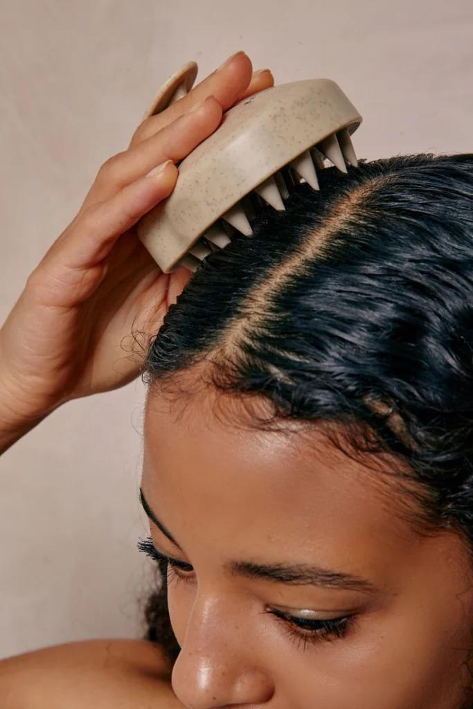 model with dark hair using a scalp brush 