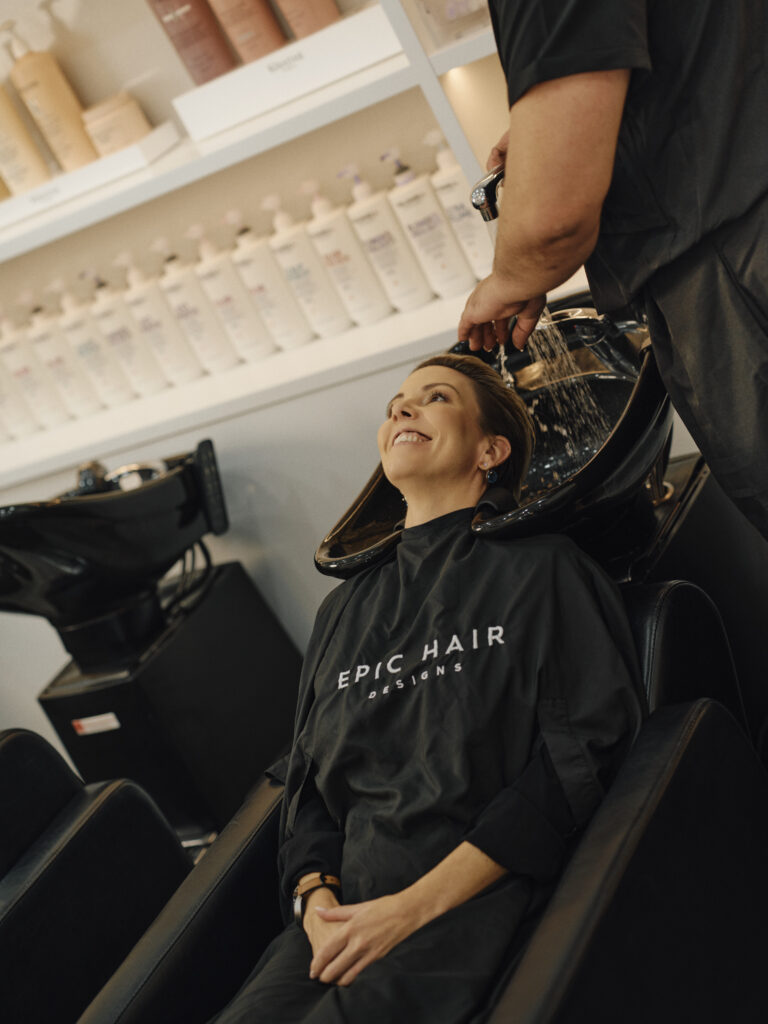 Epic client receiving professional basin care during a salon appointment
