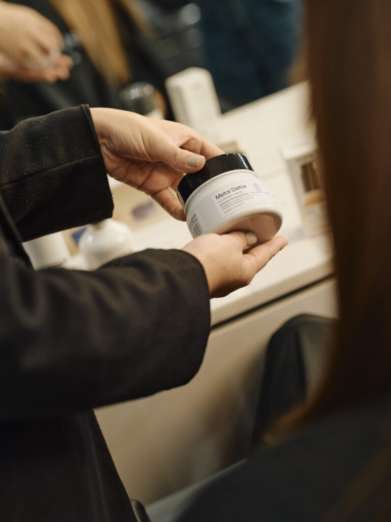 Epic team member showing L’Oréal Professionnel Metal Detox masque to a client