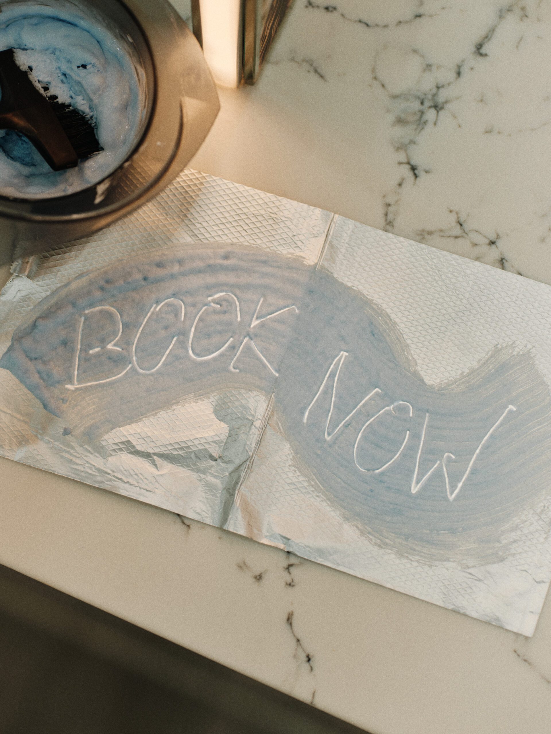 Blue salon toner swatch with the words Book Now