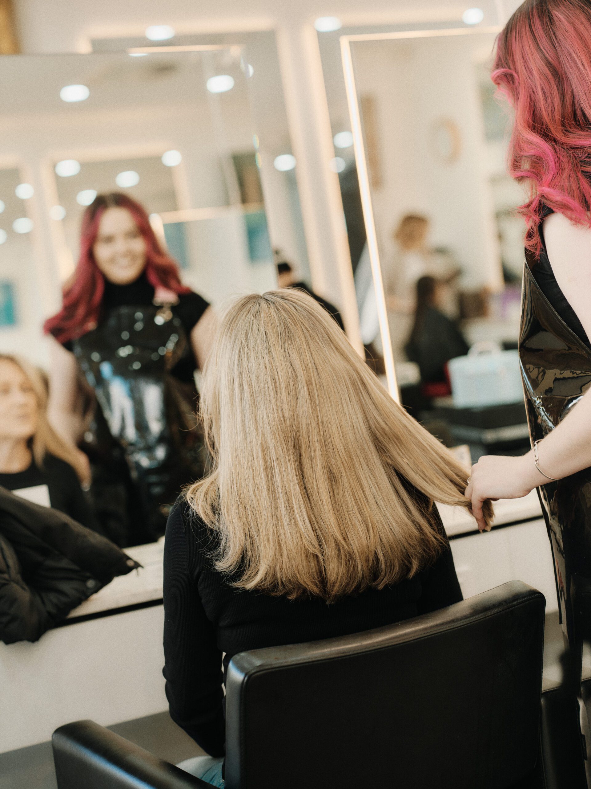 Epic Hair Designs stylist revealing a long blonde salon finish from the back