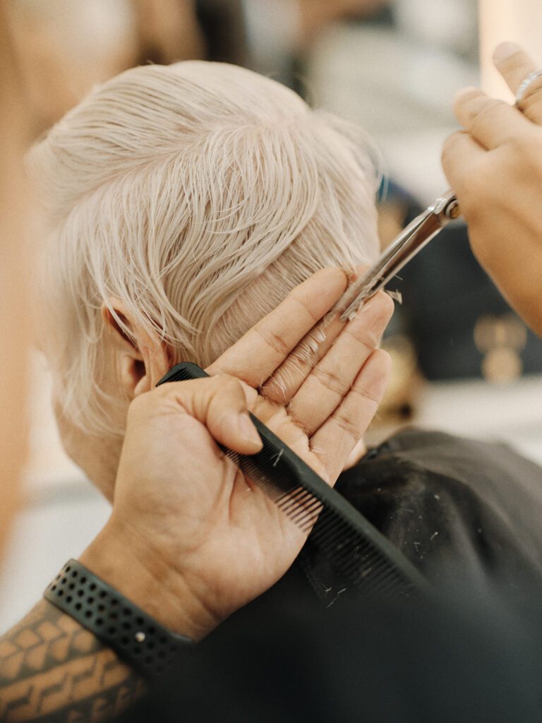 Epic stylist refining the nape of a short platinum pixie cut