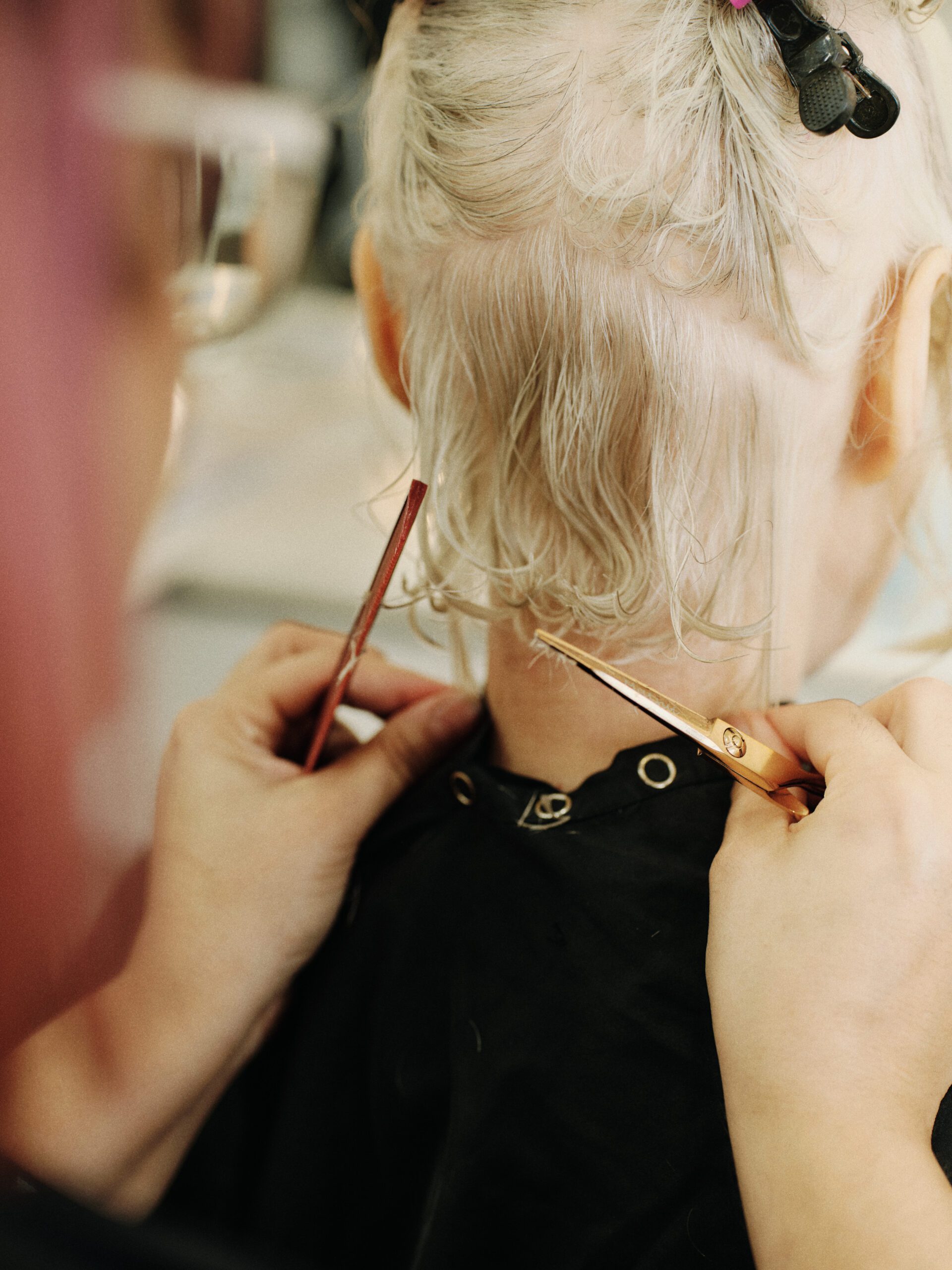 Epic Hair Designs stylist cutting the nape of a short platinum pixie style