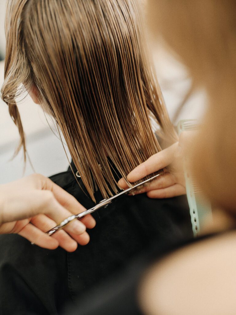 Epic stylist precision cutting the ends of wet long hair